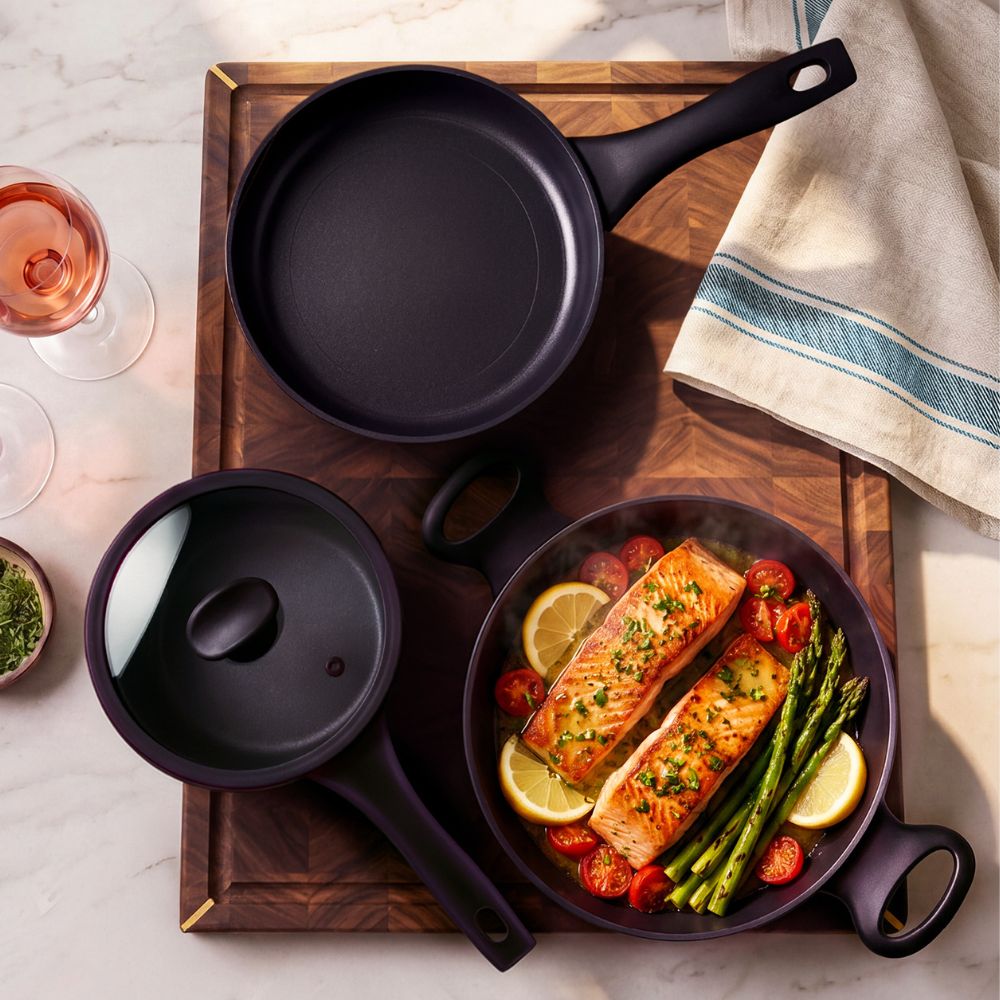 Essteele Per Domani Ceramic cookware featuring salmon and asparagus cooking in a nonstick pan.
